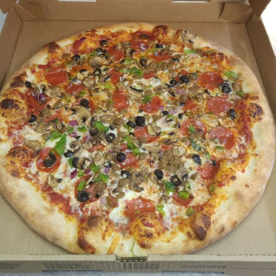 A Jaxon's Downtown pizza with pepperoni, mushrooms, olives, green peppers, and sausage in a box.