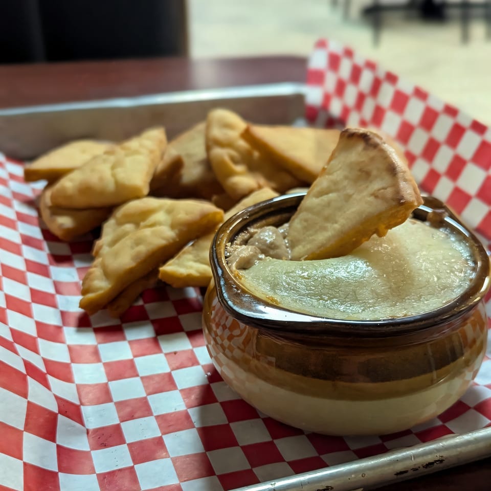 Jaxon's Downtown: A bowl of creamy dip with a pita chip, surrounded by more pita chips.